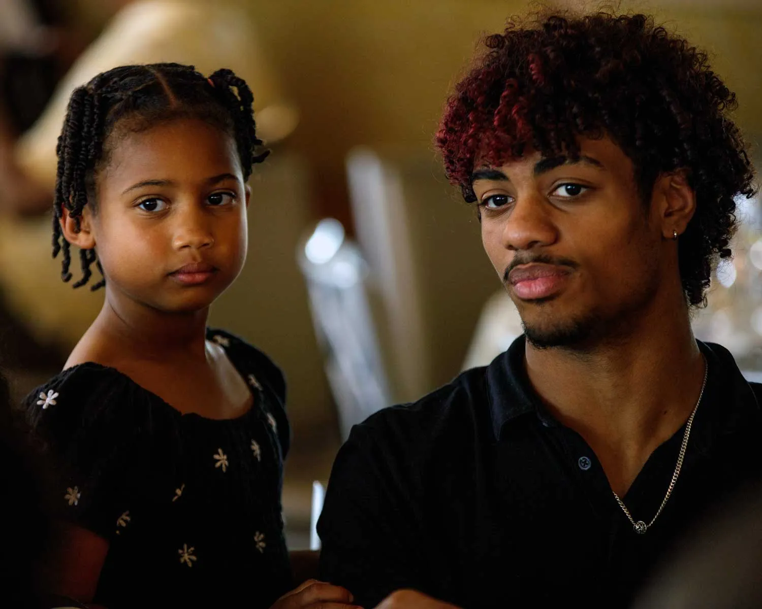 photo of a young girl and a young man listen intently to someone off camera