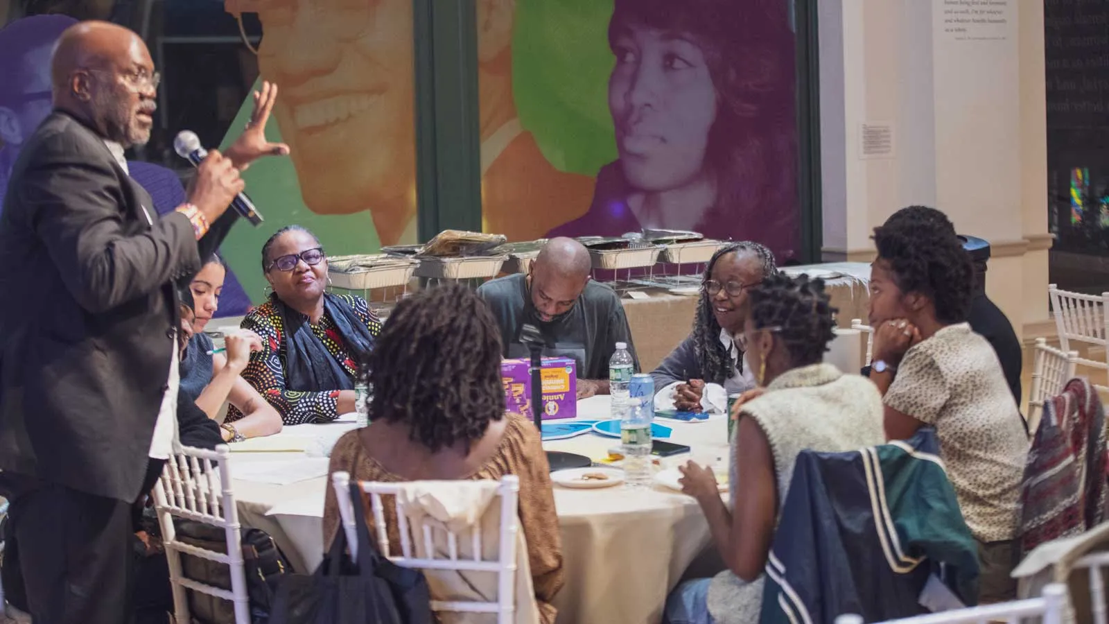 Photo of workshop in progress, one man speaking and a half dozen other men and women around a table