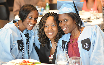 Three students smiling at the camera